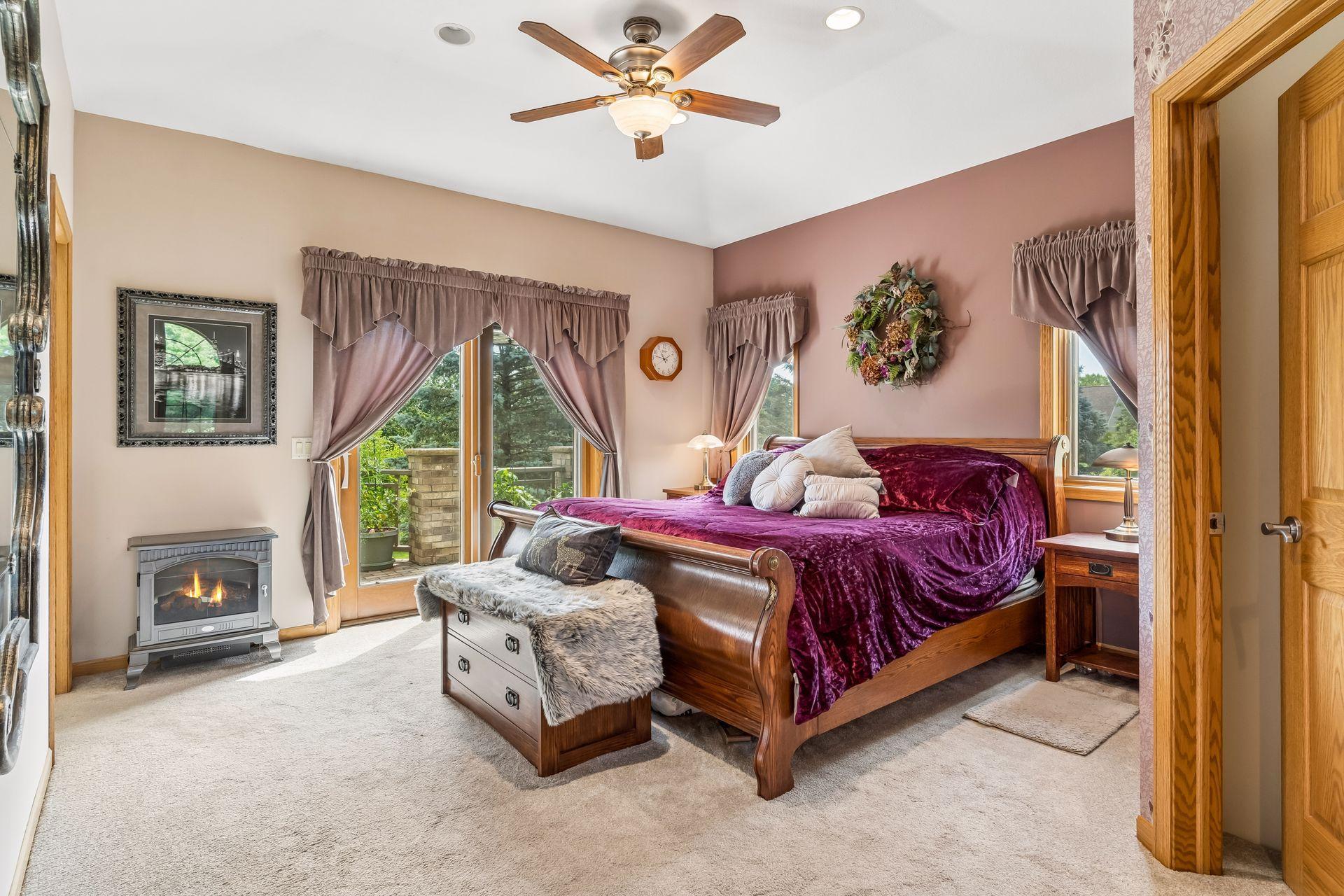 The main-level primary bedroom offers a spacious and inviting retreat with soft carpeting, generous windows, and a comfortable layout, enhanced by elegant French doors leading to the deck.