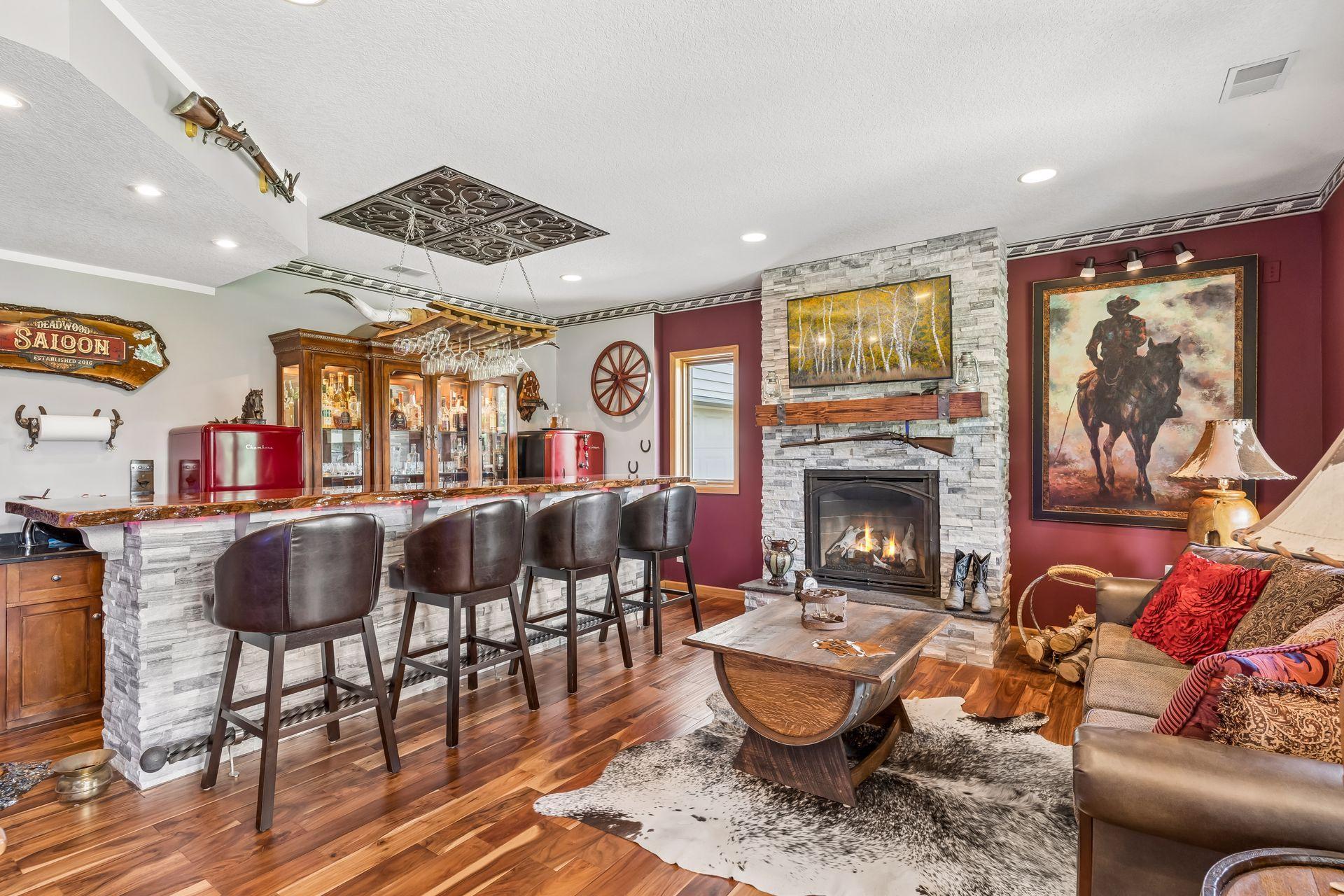 This one-of-a-kind lower-level entertaining space showcases a beautifully designed bar area with hardwood floors, abundant windows, a cozy gas fireplace, sitting area, and bar seating, (TV included). Perfect for game days, gatherings, and relaxing.