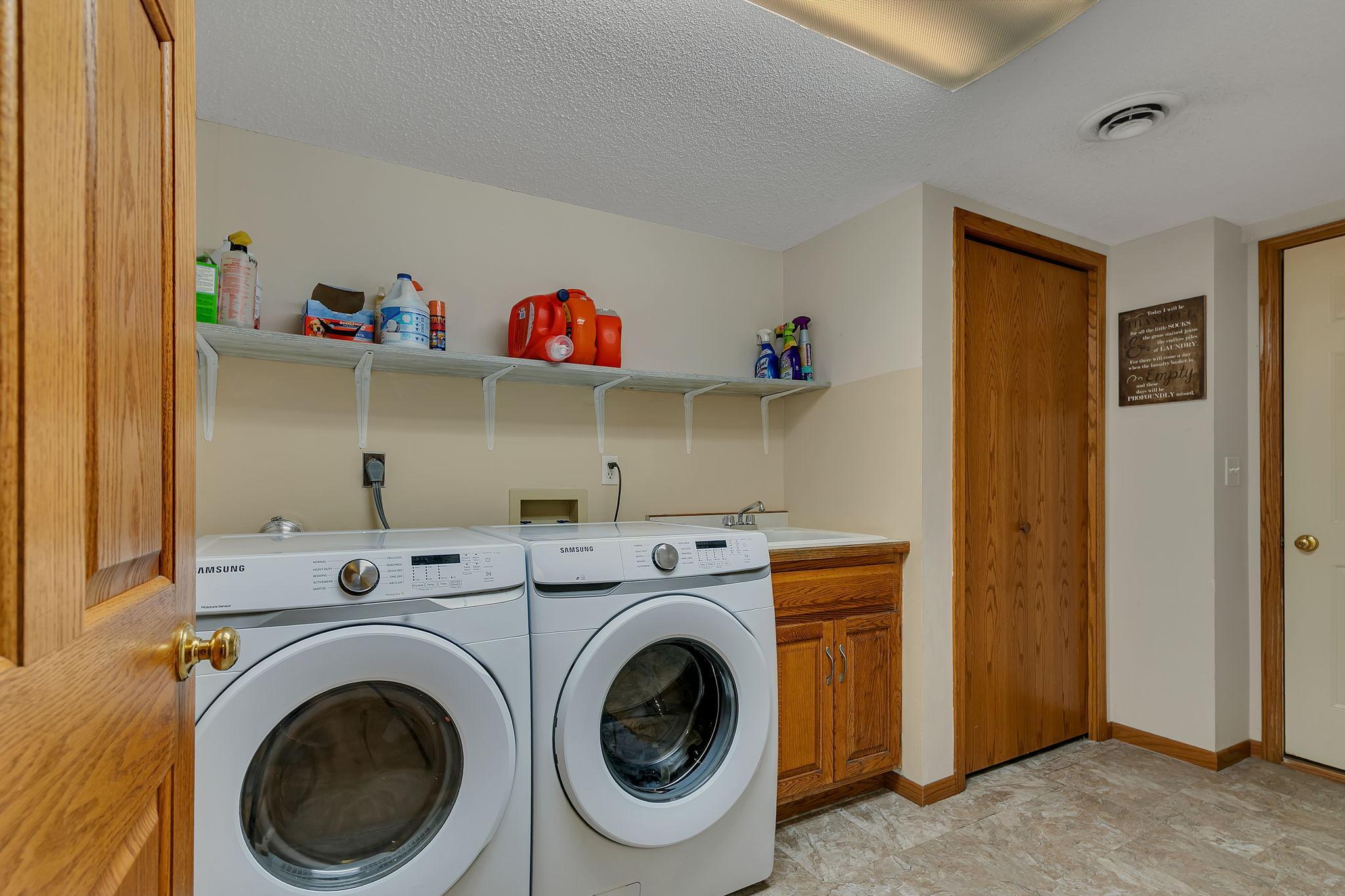 Lower level laundry room w/sink, closet and access to garage