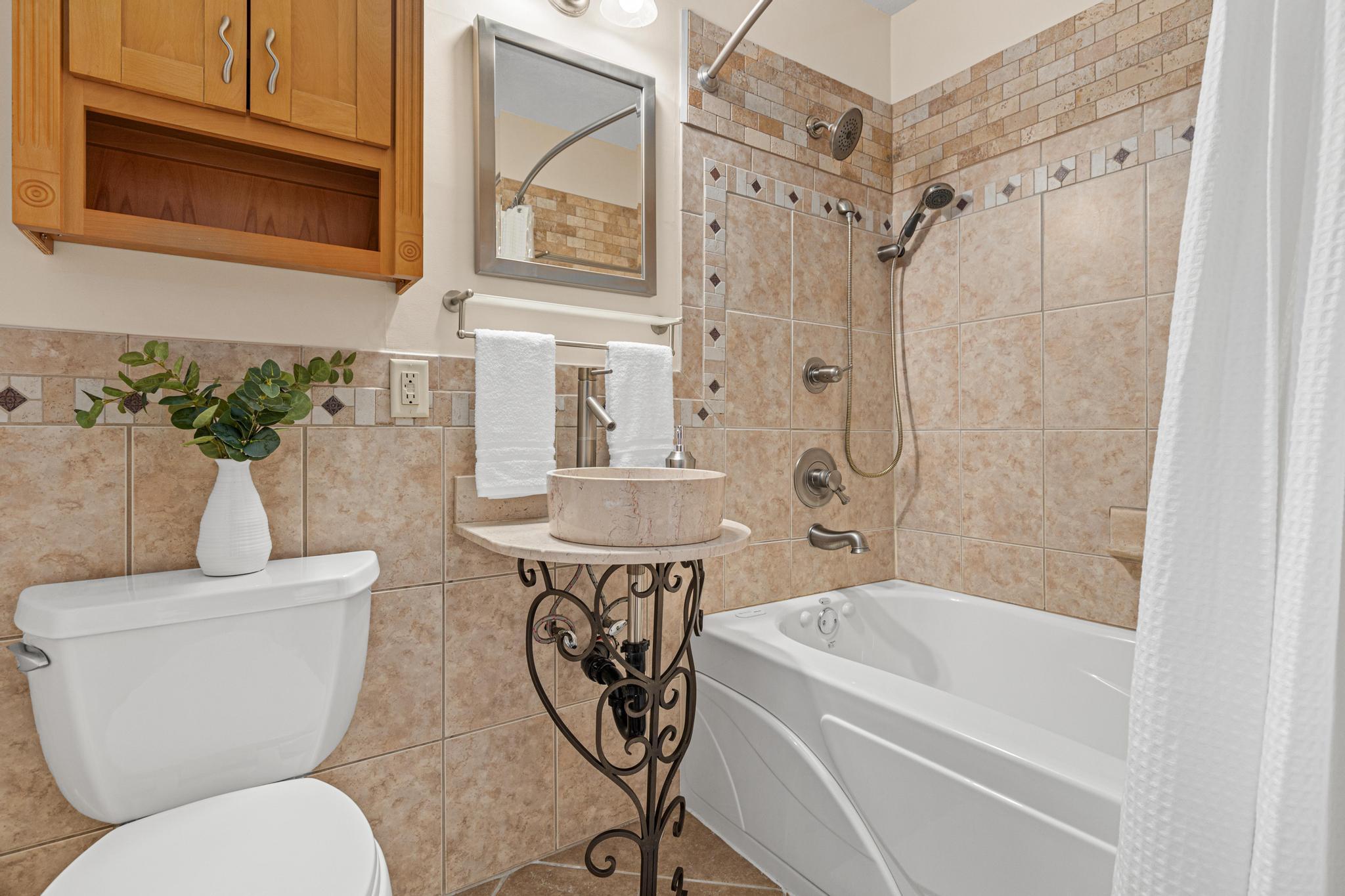 Updated full bathroom in the owners suite with stunning tile work.