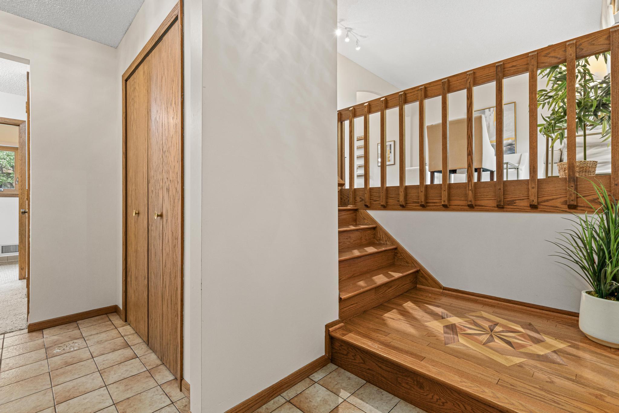 Large front foyer and hardwood steps with unique flooring inlay.