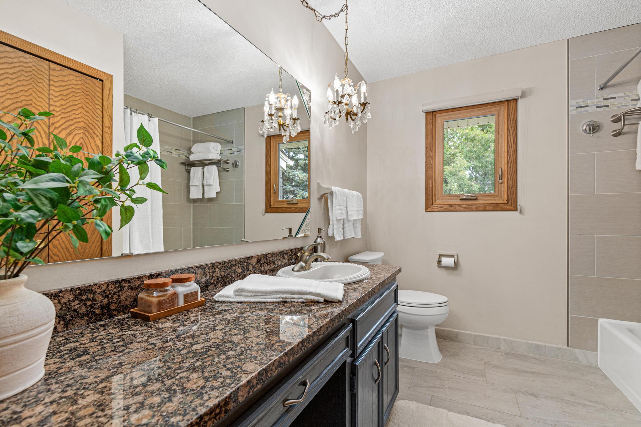 Upper level full bathroom with updated vanity/countertops, flooring and tile tub surround