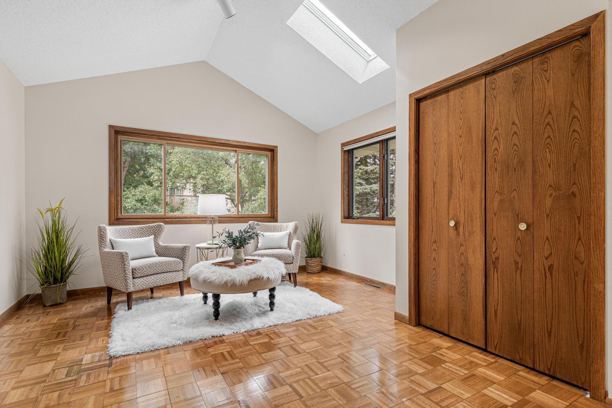Owners bedroom addition with wood flooring, vaulted ceiling and skylight.