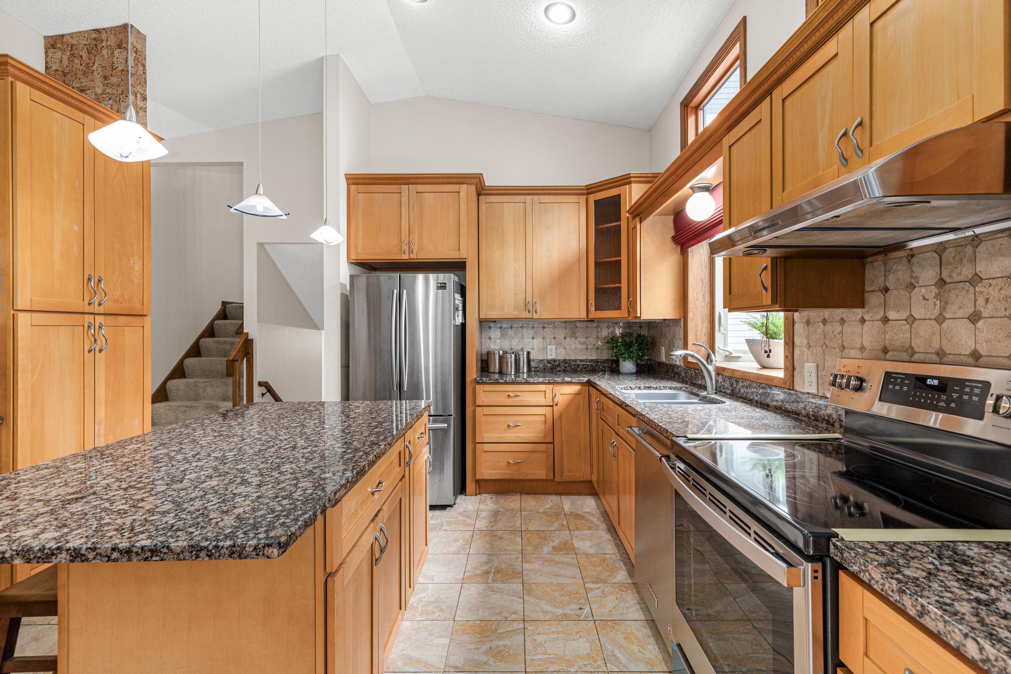 Beautifully renovated kitchen with granite countertops, stainless steel appliances, and a large center island for additional storage and countertop space.