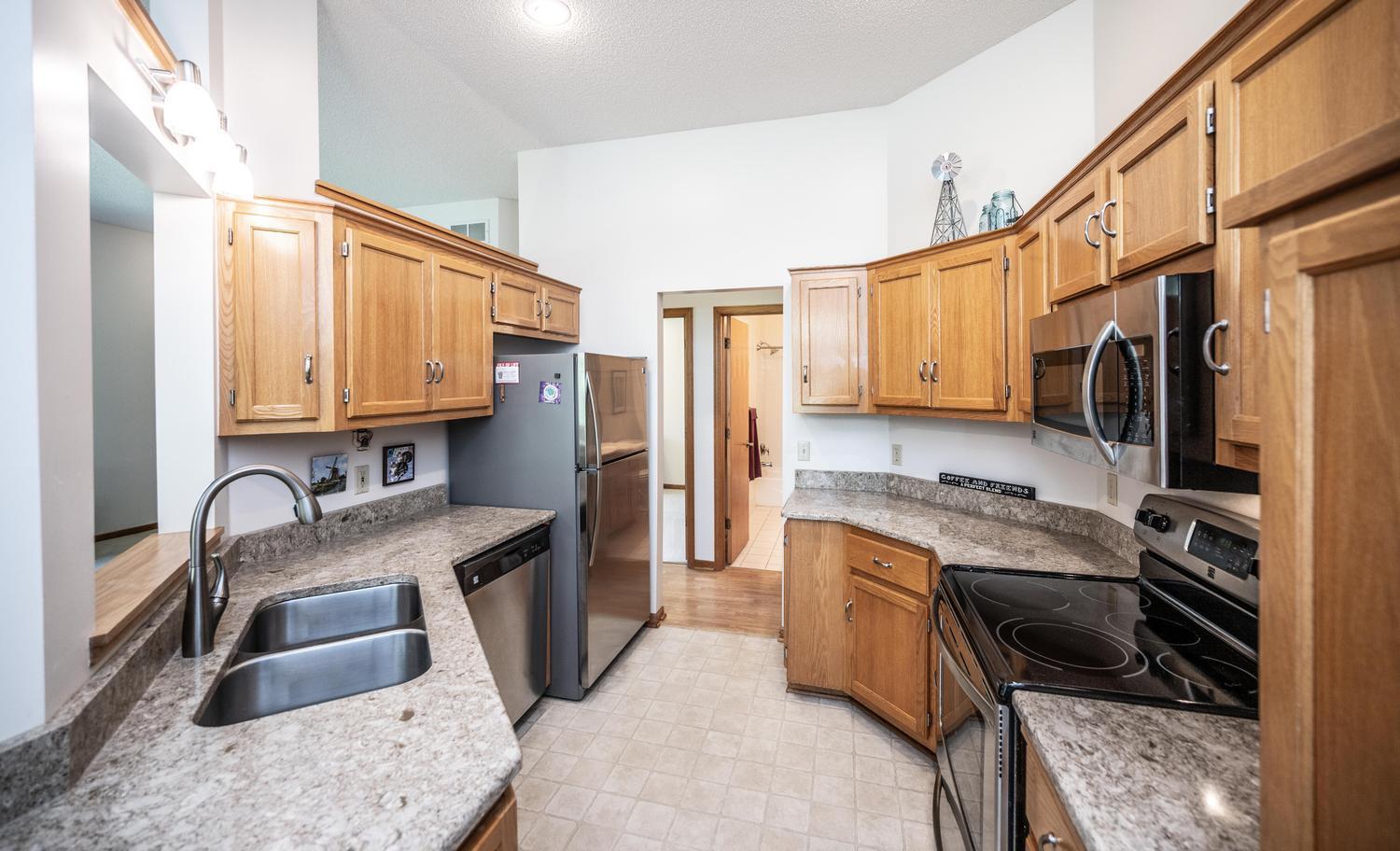 The spacious kitchen has granite countertops, stainless steel appliances and a pass-through window to the dining room