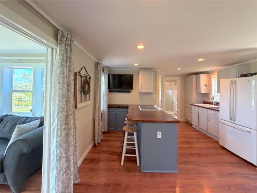 Designed with entertaining in mind, the spacious kitchen features a large center peninsula with seating and opens seamlessly to the dining area, sunroom, and lakeside living space.