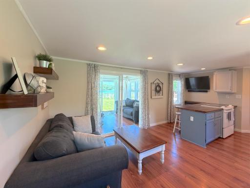 The open-concept kitchen and living room create an inviting gathering space where warm finishes, abundant natural light, and peaceful lake views come together for effortless everyday living.