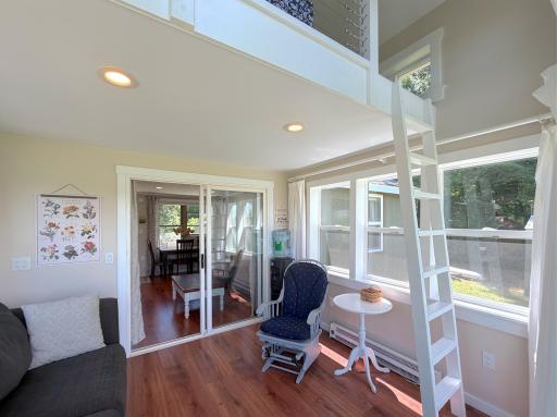 Designed to maximize the waterfront setting, the charming porch features soaring ceilings, a cozy loft above, and sliding doors that seamlessly connect to the main living area.