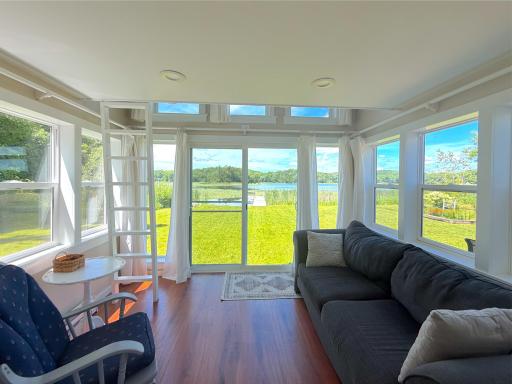 This inviting screened porch is wrapped in windows, offering panoramic lake views and the perfect place to enjoy your morning coffee or unwind at the end of the day.