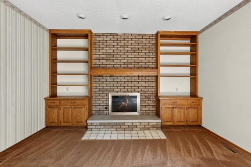 Fireplace with brick surround and built-in cabinets for storage