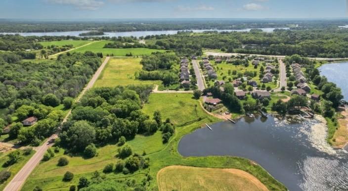 AI generated photo just showing grass instead of dirt and removal of the existing lake weeds. There will be a new dock being put in, as well as landscaping for the HOA lake outlot.