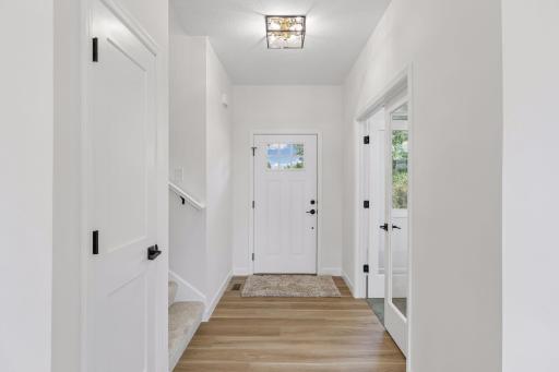 Entry door with stairs to upper level on left and office to the right