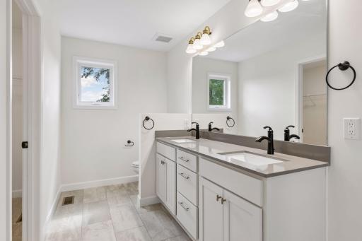 Primary bath has window, double sink and quartz counter