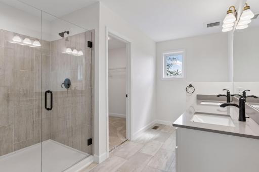 Primary bath with oversized shower walk-in closet , two sinks and quartz counter