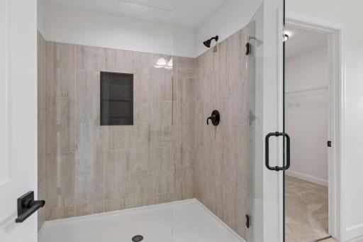 Primary bedroom oversized walk-in shower with bi-directional swinging door