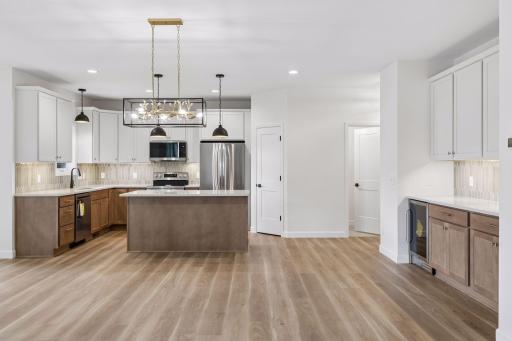 Beautiful kitchen and dining area with plenty of cabinets, large island and beverage frig