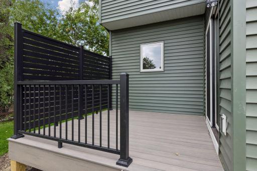 Composite deck provides view of backyard with privacy panel