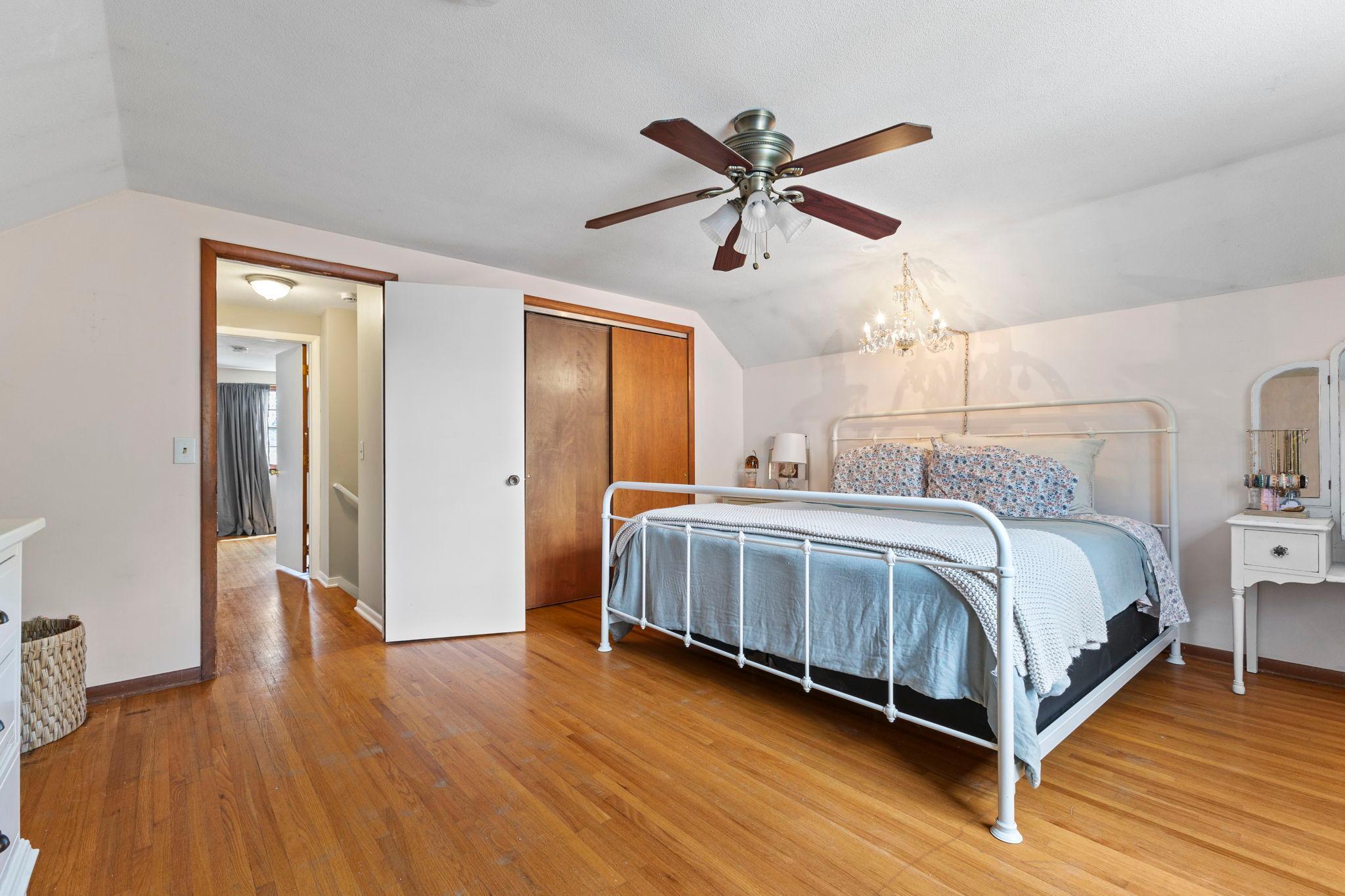 This spacious bedroom showcases beautiful hardwood flooring and generous natural light.