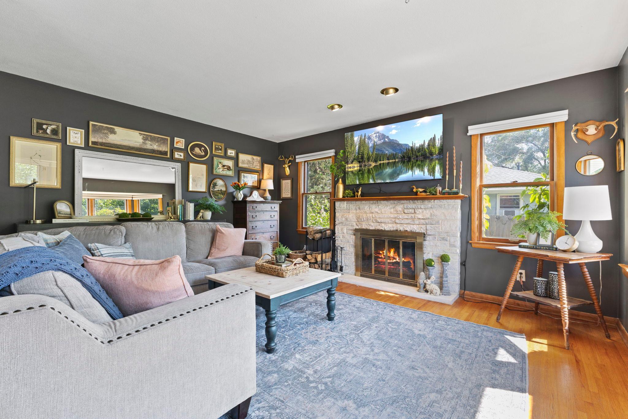 Large windows fill the living room with natural light while overlooking the beautiful, well kept yard.