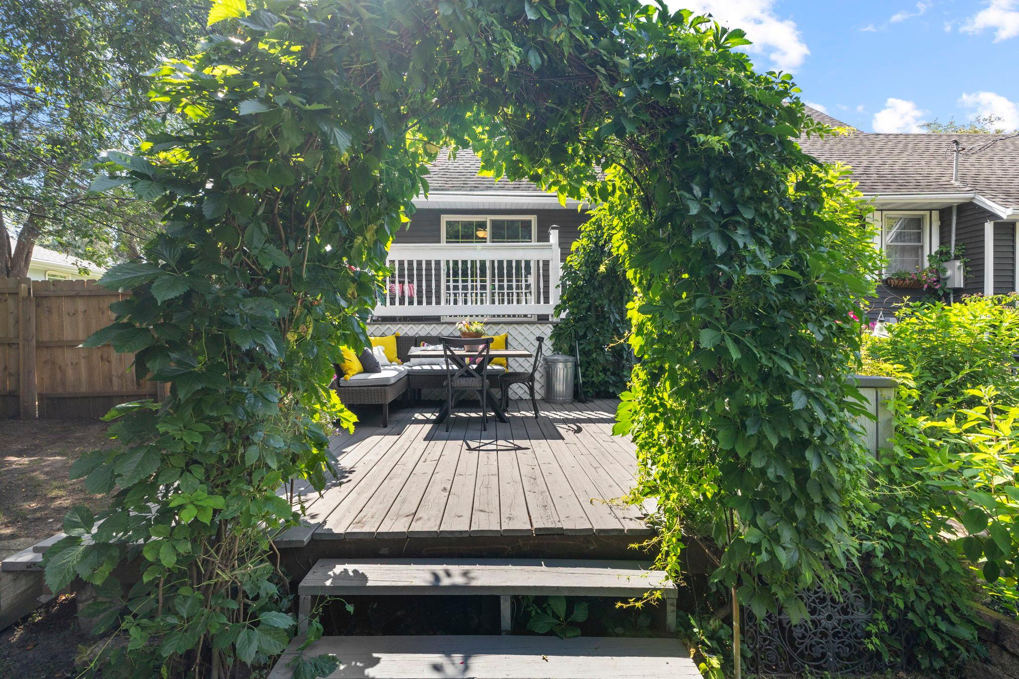 The garden arbor creates a picturesque entrance to the backyard.