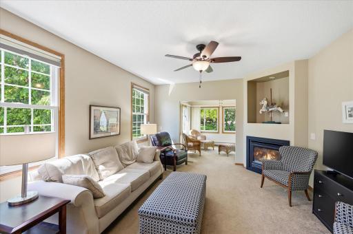 The open-concept living room is filled with natural light and features a cozy gas fireplace, and a seamless flow into the sunroomâcreating an inviting space for everyday living and entertaining.