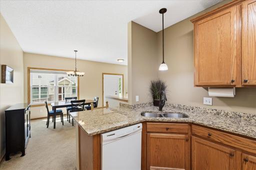 Designed for both functionality and connection, the kitchen features granite countertops, hardwood floors, abundant cabinetry, and an open peninsula overlooking the dining areaâperfect for everyday living and entertaining.