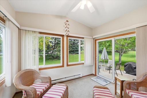 Relax year-round in the light-filled four-season sunroom, where walls of windows invite the outdoors in and offer beautiful views of the expansive green space with direct access to the patio.