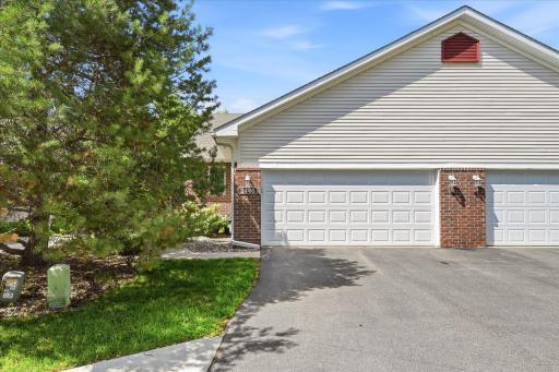 Beautifully maintained end-unit townhome featuring an attached two-car garage, private driveway, mature landscaping, and exceptional curb appeal in one of Chanhassen's most convenient locations.