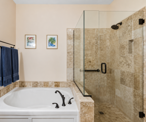 Spa-inspired owner's bath features a luxurious soaking tub, beautifully tiled walk-in shower with glass enclosure, granite dual-sink vanity, and timeless finishesâcreating the perfect retreat at the end of the day.