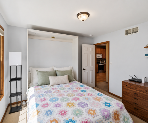 A custom Murphy bed, included with the home, transforms this versatile room into an ideal guest suite while preserving valuable floor space for everyday use.