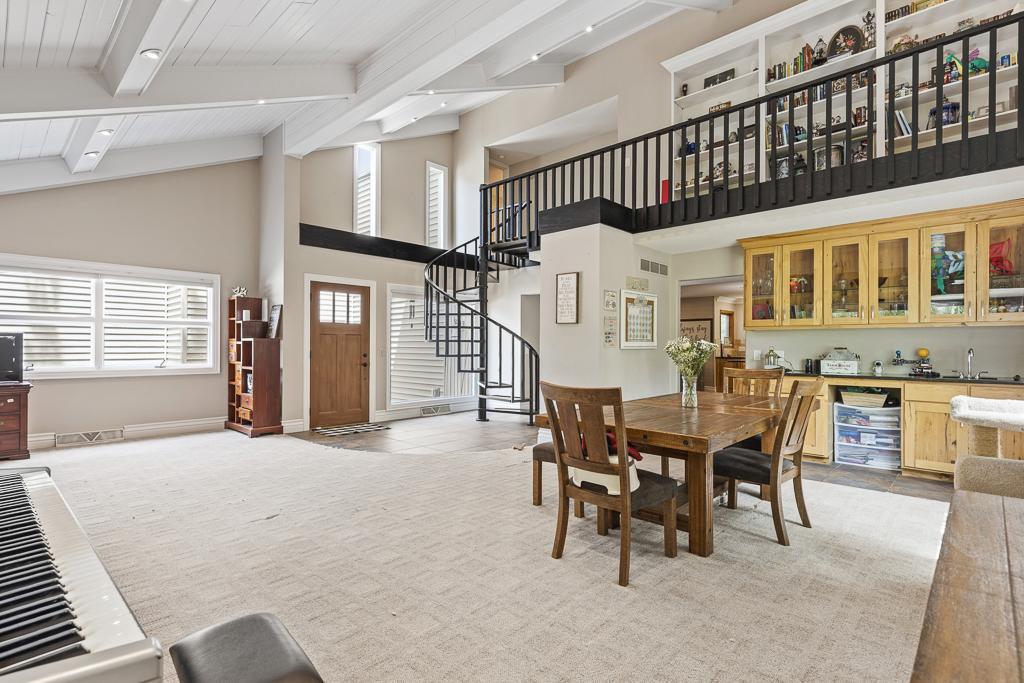 Step inside and be blown away by the vaulted ceiling and a spiral staircase leading to an open balcony (this space also features a wet bar with the perfect space underneath for a wine fridge!)