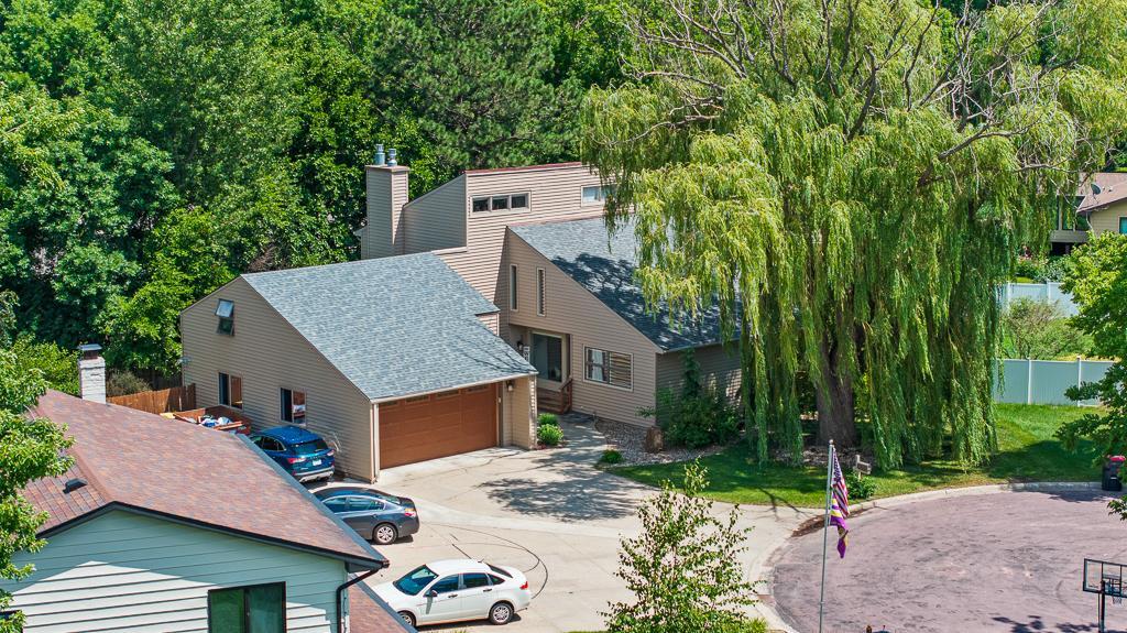 The unique architecture of the home is eye-catching, while a mature willow tree shades the front of the home and adds a stunning natural element