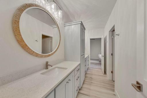 Well-appointed Jack-and-Jill bathroom conveniently connecting two spacious lower-level bedrooms with dual vanities and custom cabinetry.
