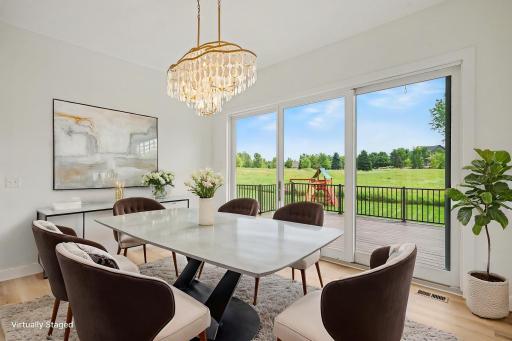 Light-filled dining area with designer chandelier, expansive windows, and serene backyard viewsâperfect for everyday meals and elegant entertaining. (Virtually staged photo)