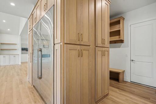 Abundant storage is available in the wrap-around floor to ceiling custom cabinetry that extends from kitchen into back entry area.
