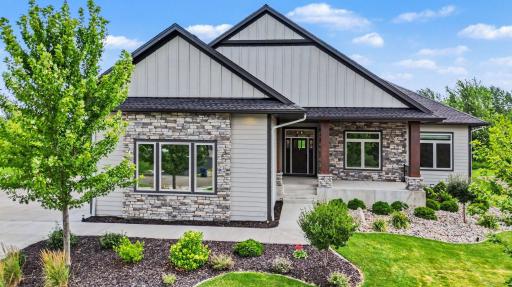 Striking Craftsman-inspired exterior showcasing timeless stone accents, board-and-batten siding, and exceptional architectural detail.