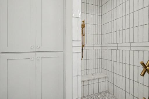 Beautifully crafted spa shower with custom tilework, built-in niches and bench seating, creating a true retreat experience.