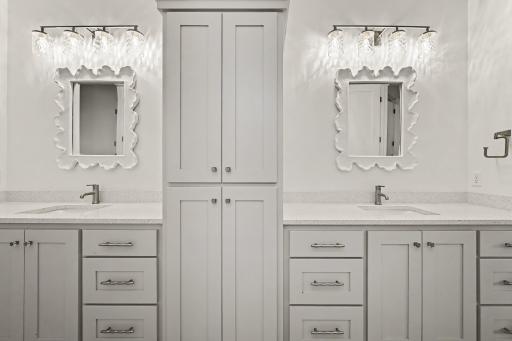 Thoughtfully designed shared bath with dual sinks, abundant storage, and a private linen cabinet for added convenience.