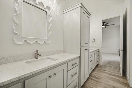 Bright and beautifully finished Jack-and-Jill bath showcasing quartz surfaces, custom cabinetry, and timeless designer finishes.