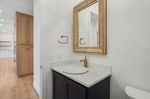 Stylishly appointed main-level bathroom featuring quartz countertops, designer fixtures, and custom cabinetry.