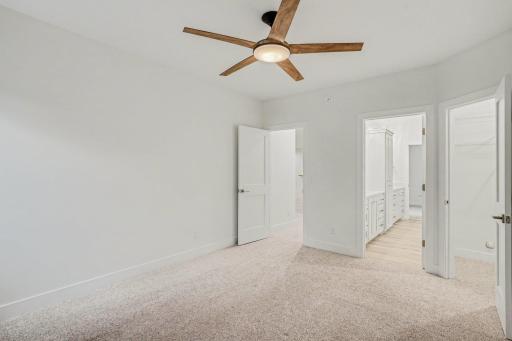 Spacious lower-level bedroom offering plush carpeting, a generous closet, and direct access to the adjoining Jack-and-Jill bathroom.