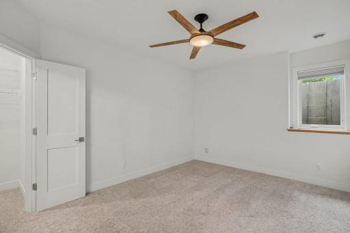 Spacious lower-level bedroom with plush carpeting, oversized closet, and a comfortable retreat for family or overnight guests.