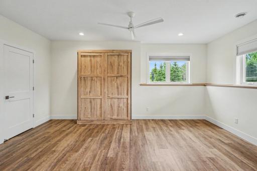 Versatile lower-level bedroom featuring a custom built-in Murphy-style cabinet with integrated trundle bedâperfect for guests, a home office, or flexible living.