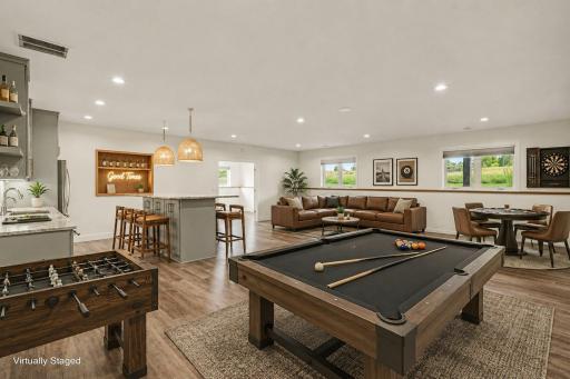 Expansive lower-level recreation room with ample space for billiards, entertaining, and seamless connection to the family room and wet bar. (Virtually staged photo)