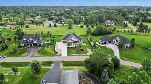 Aerial view showcasing the home's premier setting within The Territory, surrounded by scenic greenspace, luxury homes, and the golf course community.