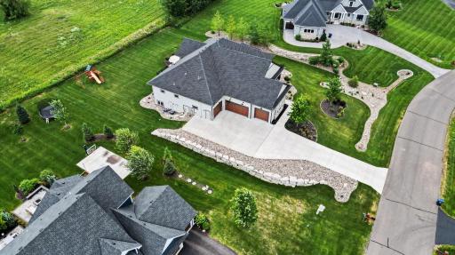 Impressive aerial perspective highlighting the home's expansive lot, oversized four-car garage, professionally landscaped grounds, and exceptional curb appeal.