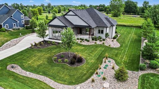 Stunning aerial perspective highlighting the home's impressive architecture, professionally landscaped grounds, and premium golf course setting.
