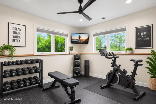 Dedicated fitness room with abundant natural light, creating the perfect space for workouts, yoga, or a private home gym. (Virtually staged photo)
