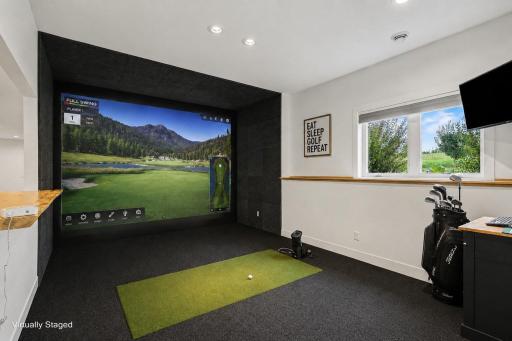 Dedicated golf simulator room offers a private space to perfect your swing and enjoy year-round recreation from the comfort of home. (Virtually staged photo)