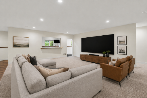 Inviting lower-level family room designed for relaxing and entertaining, featuring an open-concept layout with abundant gathering spaces. (Virtually staged photo)